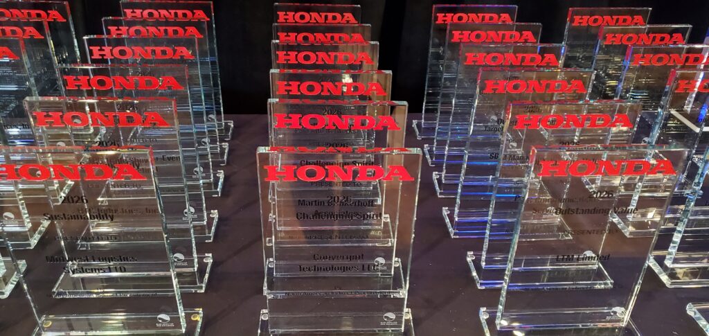 37 plexiglass awards sitting on a table from Honda